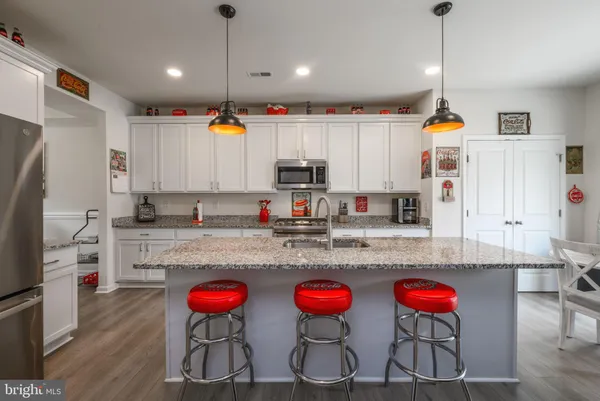 a kitchen with stainless steel appliances granite countertop a stove a sink and a refrigerator