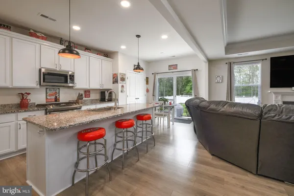 a living room with furniture a flat screen tv and kitchen view