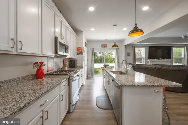 a kitchen with stainless steel appliances granite countertop a lot of counter space and wooden floors