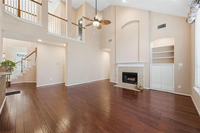 a view of a livingroom with wooden floor a fireplace and window