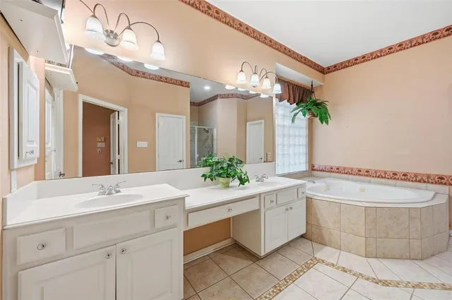 a bathroom with a tub a sink and mirror