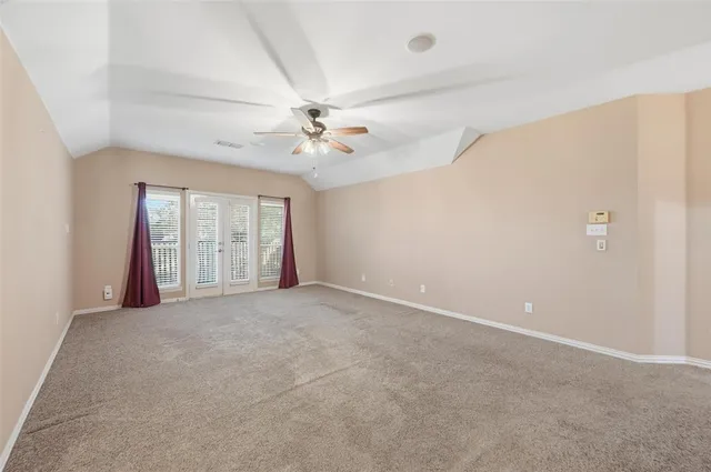 an empty room with windows and ceiling fan