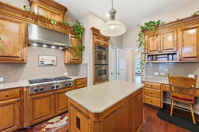 a kitchen with stainless steel appliances granite countertop a stove a sink dishwasher and cabinets with wooden floor