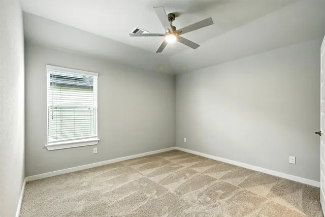 an empty room with closet and a chandelier fan