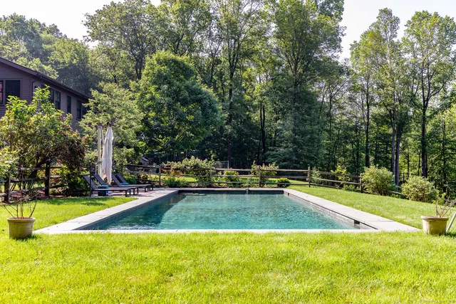 a view of a swimming pool with an outdoor seating and a yard