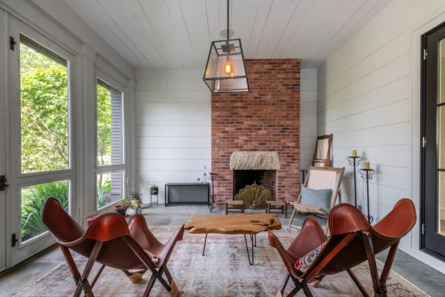 a living room with furniture fireplace and a large window