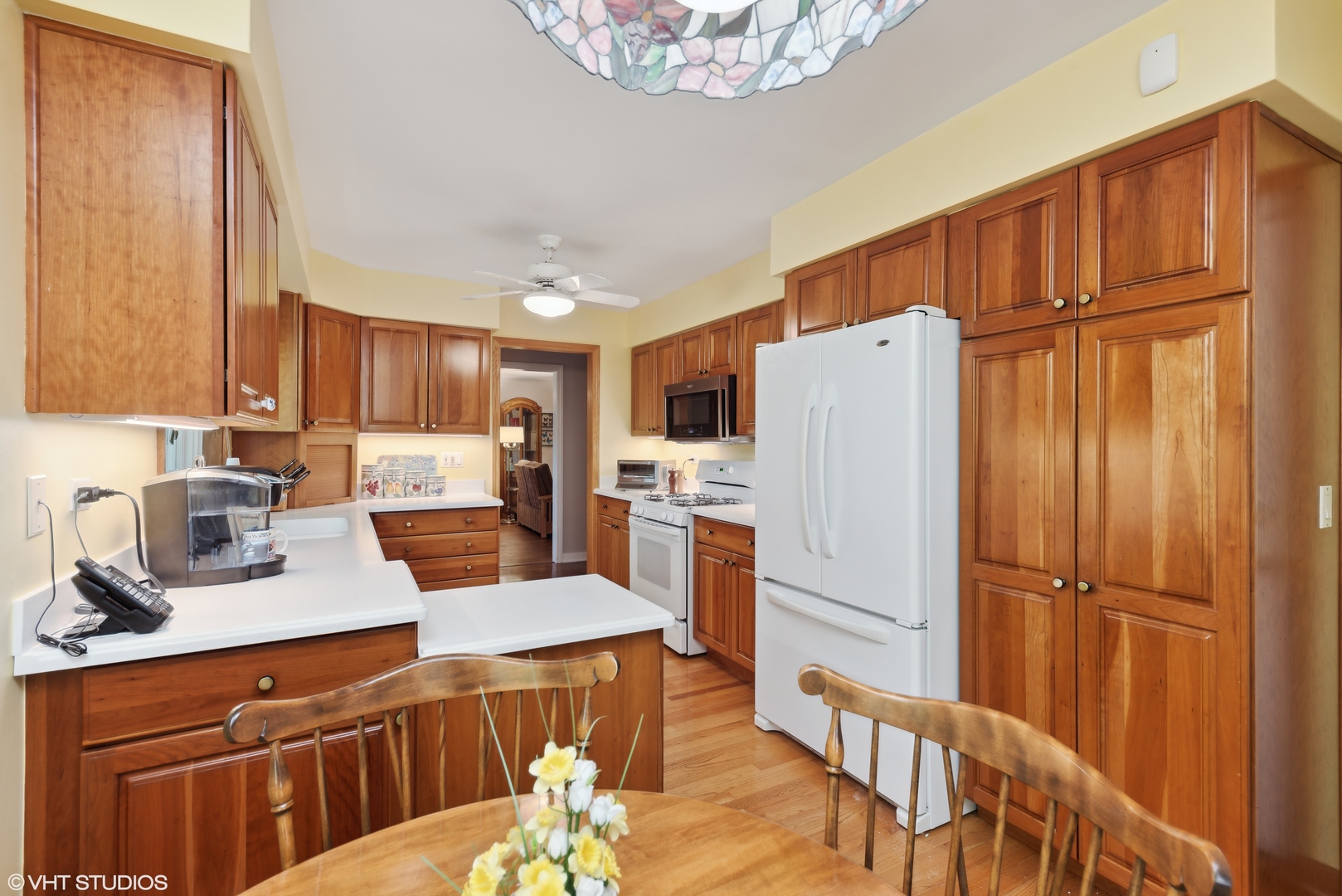 2416 Covert Road Glenview, IL 60025 - Photo 8 of 24 a kitchen with granite countertop a refrigerator a sink dishwasher a stove and a dining table with wooden floor