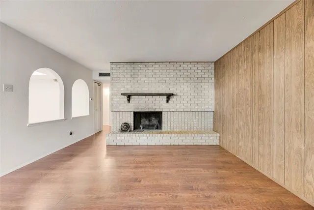 a view of an empty room with a fireplace and a window