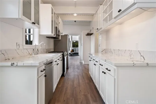 a kitchen with granite countertop a sink stove and cabinets