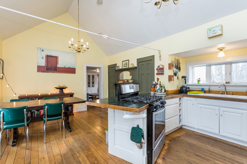 1301 Conway Road Ashfield, MA 01330 - Photo 8 of 26 a kitchen with stainless steel appliances granite countertop a stove top oven a sink dishwasher a dining table and chairs with wooden floor
