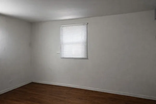 a view of a small space with wooden floor and a window