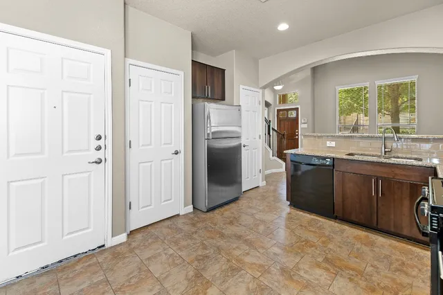 a kitchen with stainless steel appliances granite countertop a sink stove and refrigerator