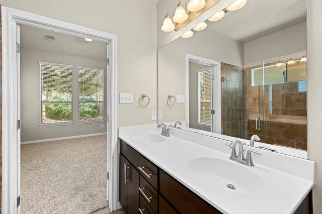 a bathroom with a sink a vanity a mirror and a shower