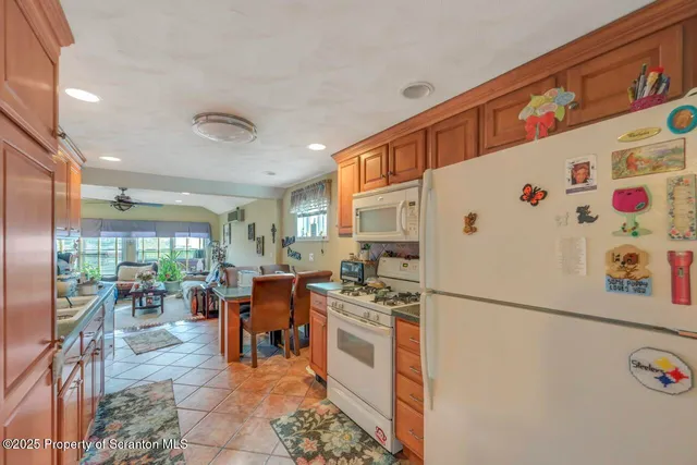 a kitchen with stainless steel appliances granite countertop a refrigerator a stove and a wooden cabinets