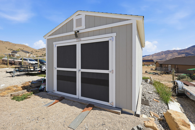 1588 West Rim Rock Drive Stockton, UT 84071 - Photo 39 of 61 Exterior storage shed featuring light gray siding, white trim, a gabled roof, and double entry doors
