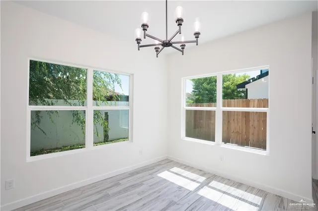 a view of a room with wooden floor and a ceiling fan