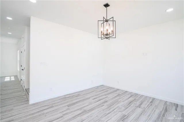 an empty room with wooden floor and ceiling fan