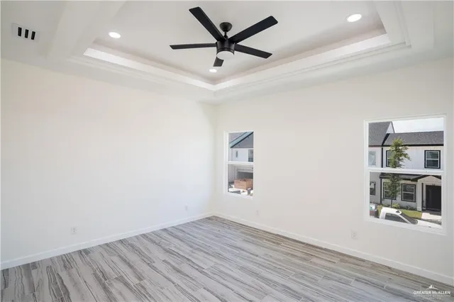 an empty room with a window and a ceiling fan