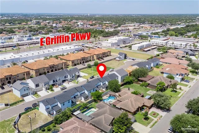 a view of an empty room with wooden floor and windows
