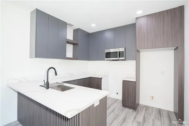 a kitchen with a sink a refrigerator and cabinets