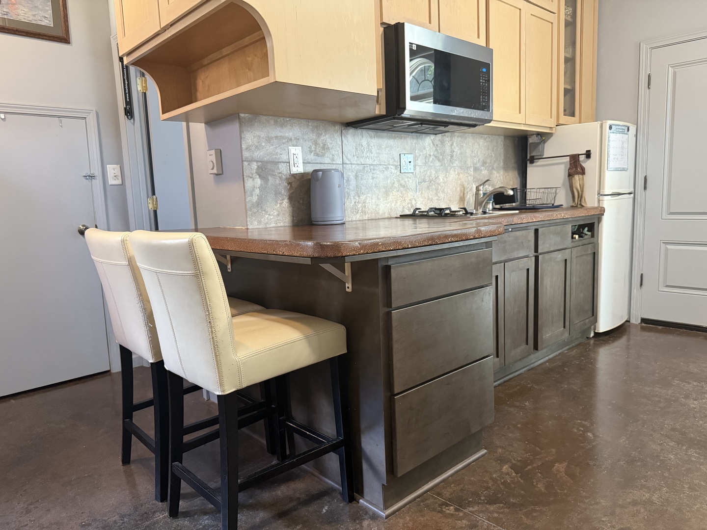 186 Peru Street Paw Paw, IL 61353 - Photo 12 of 27 a kitchen with stainless steel appliances granite countertop a table chairs microwave and sink