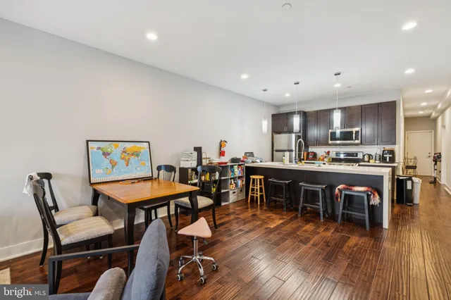 a living room with furniture and a dining table with kitchen view