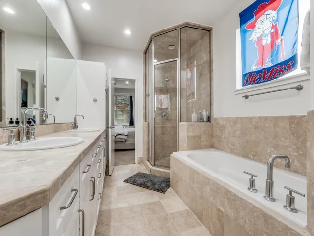 a bathroom with a tub sink and mirror