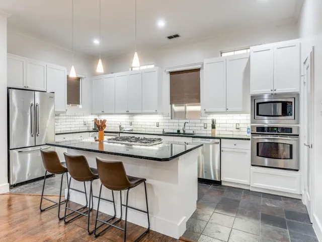 a kitchen with sink a refrigerator and cabinets