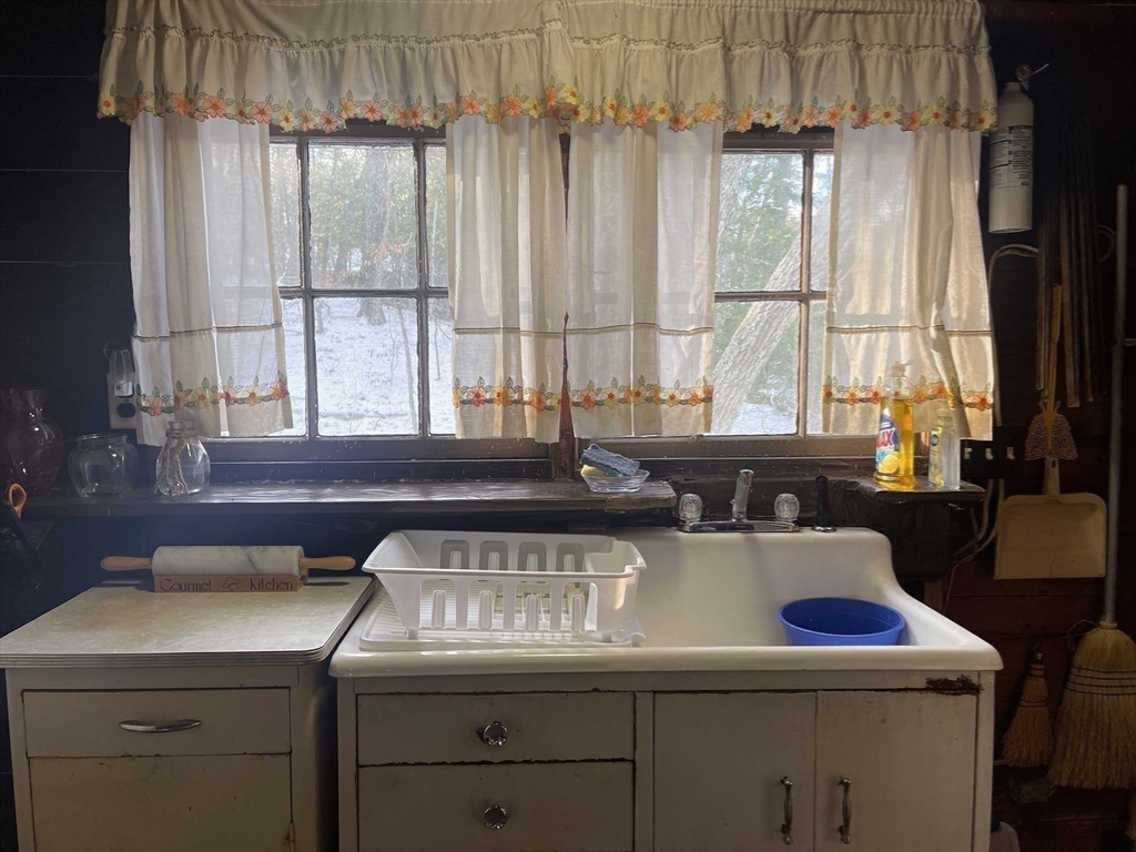172 Shelters Road Groton, MA 01450 - Photo 16 of 40 a view of a kitchen with a sink a large window appliances and cabinets