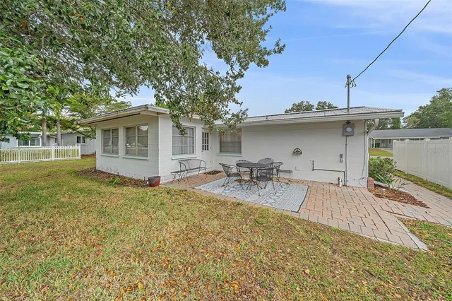an aerial view of residential houses with outdoor space and trees