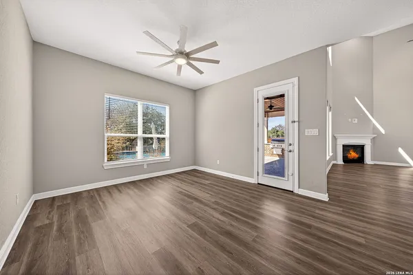 an empty room with ceiling fan and windows