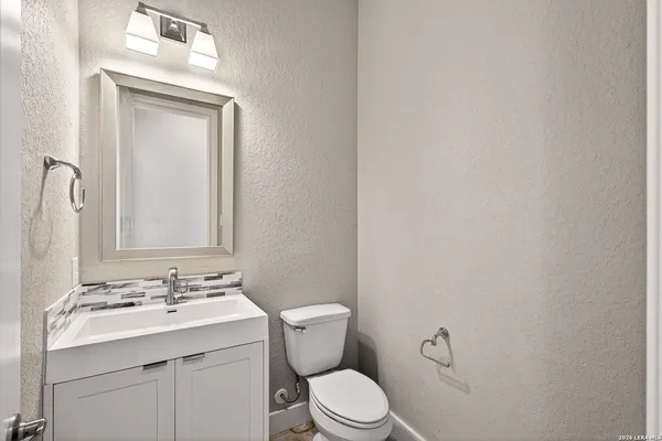 a bathroom with a granite countertop sink toilet a mirror and shower