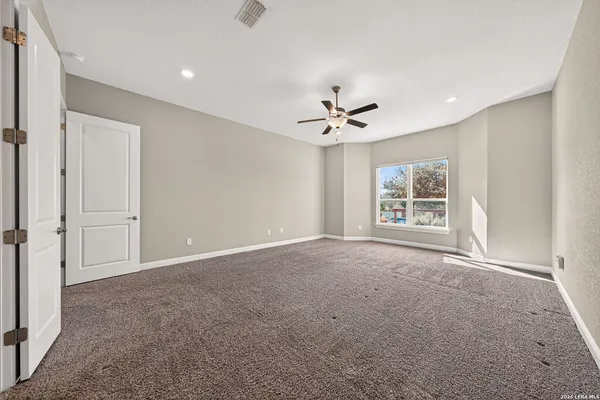 a view of an empty room with a chandelier fan
