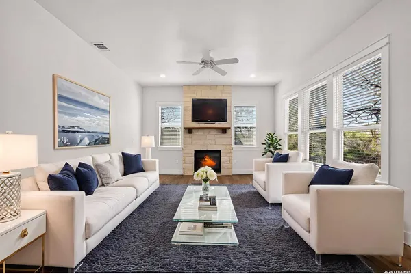 a view of an empty room with wooden floor fireplace and a window