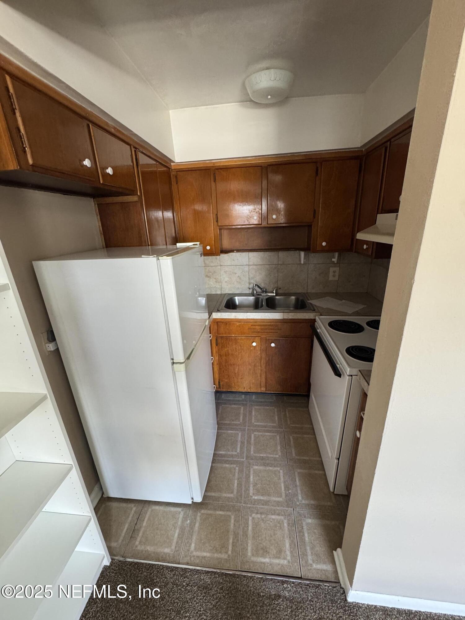 916 Childrens Way, Unit 7 Jacksonville, FL 32207 - Photo 3 of 10 a kitchen with a sink a stove top oven and cabinetry