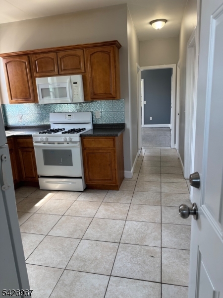 23 Elliott Street Newark, NJ 07104 - Photo 19 of 25 a kitchen with a sink a stove and a refrigerator