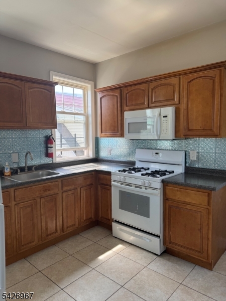 23 Elliott Street Newark, NJ 07104 - Photo 20 of 25 a kitchen with granite countertop stainless steel appliances a sink window and cabinets