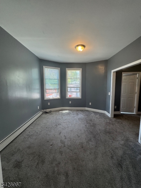 23 Elliott Street Newark, NJ 07104 - Photo 4 of 25 an empty room with windows and closet