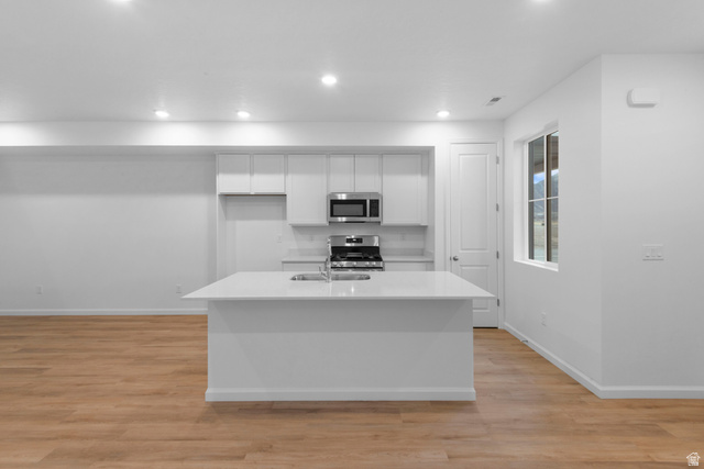 1302 East 1670th North, Unit 908 Payson, UT 84651 - Photo 3 of 21 Kitchen with white cabinetry, a kitchen island with sink, light wood finished floors, stainless steel appliances, and recessed lighting