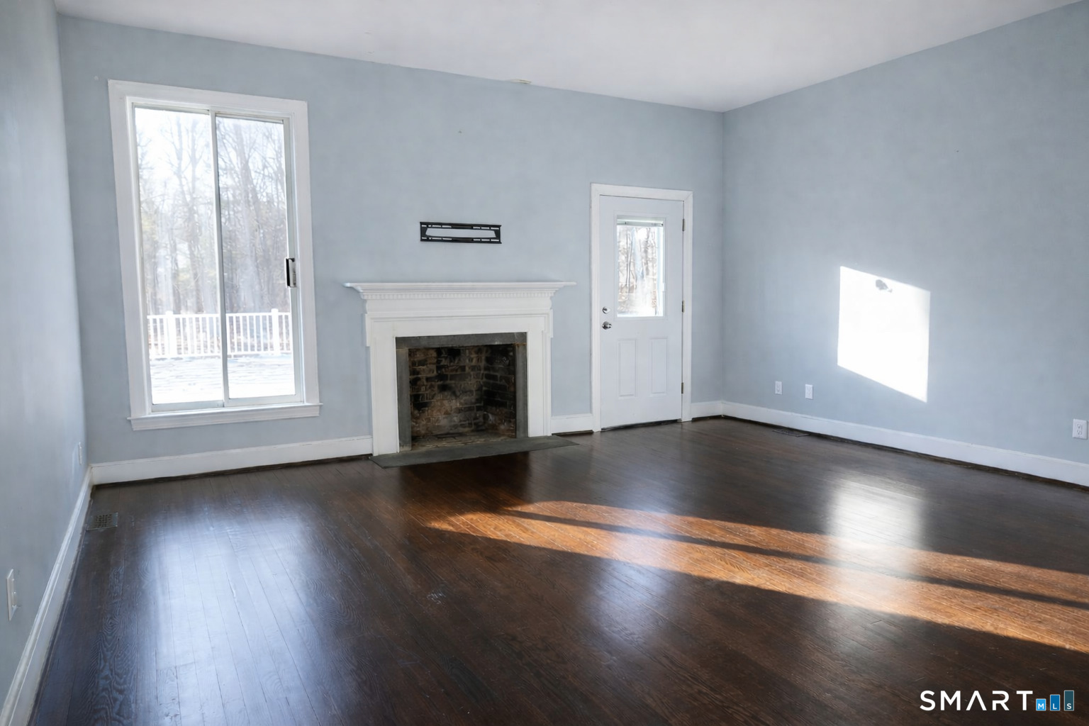 2079 Portland-Cobalt Road Portland, CT 06480 - Photo 4 of 13 an empty room with wooden floor fireplace and windows