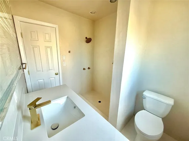 a bathroom with a sink a toilet and shower