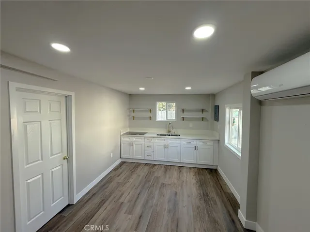 a large kitchen with a lot of counter space and wooden floor