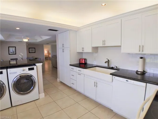 a kitchen with cabinets sink and washer dryer