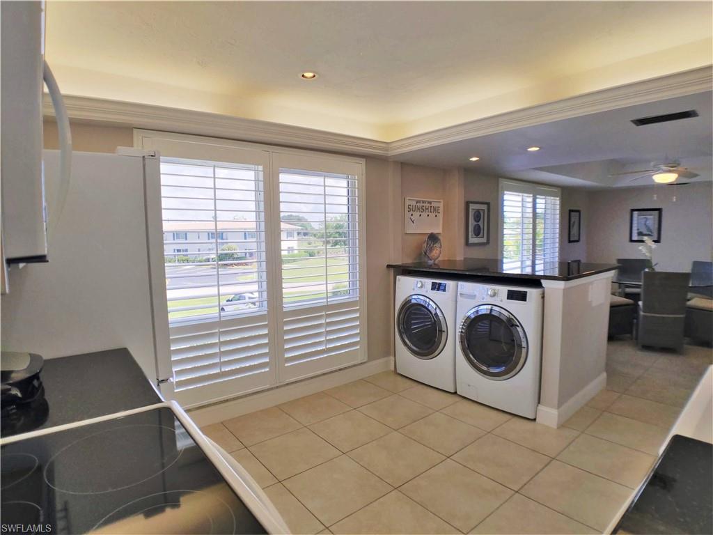 108 Penny Lane, Unit 4 Naples, FL 34112 - Photo 19 of 33 a utility room with dryer washer and a view of living room