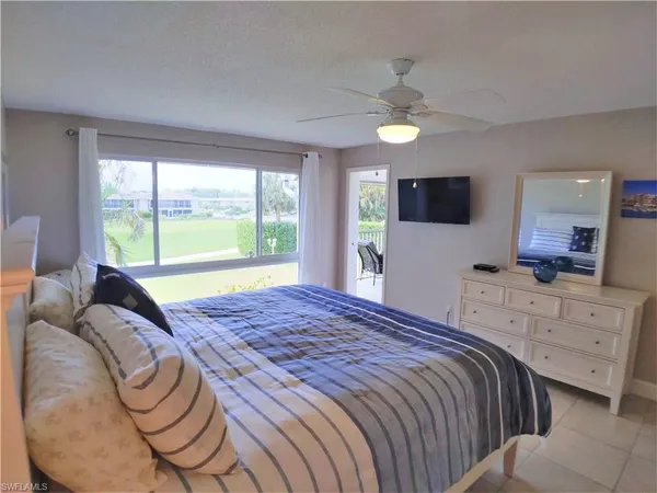 a bedroom with a bed and a large window