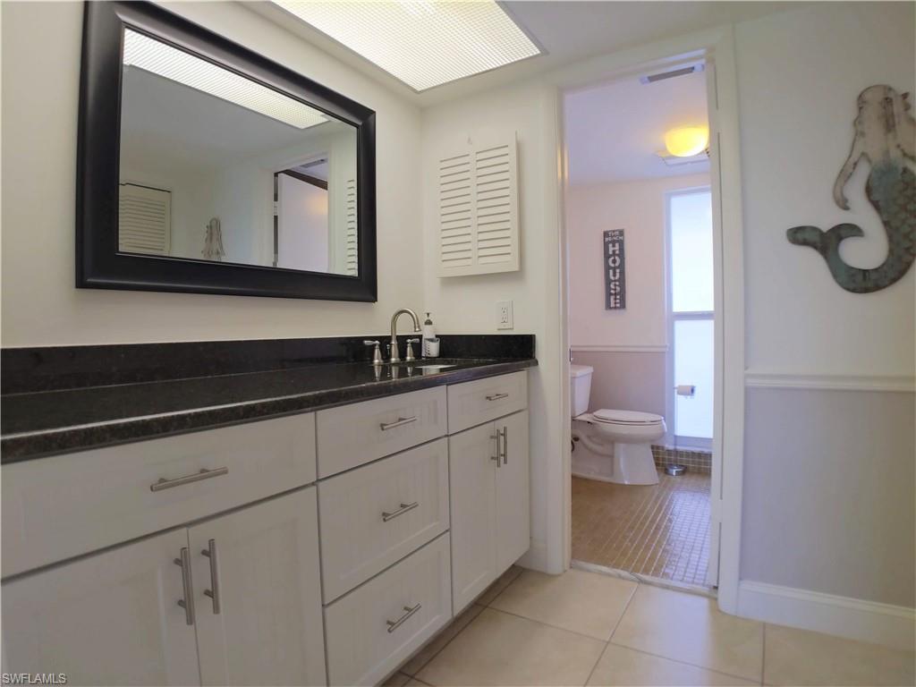 108 Penny Lane, Unit 4 Naples, FL 34112 - Photo 26 of 33 a bathroom with a toilet sink and mirror