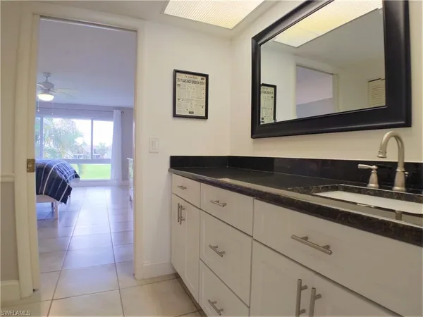 a bedroom with a bed and a flat tv screen on dresser