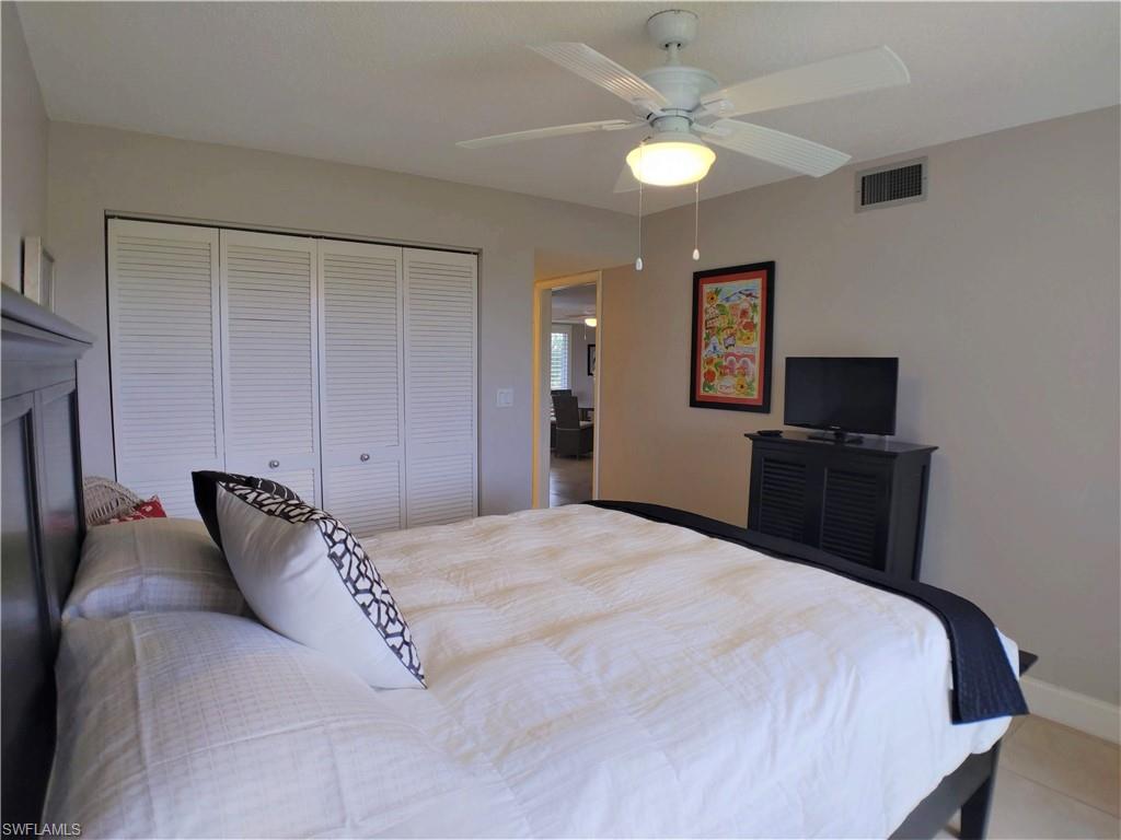 108 Penny Lane, Unit 4 Naples, FL 34112 - Photo 30 of 33 a bedroom with a bed and a tv