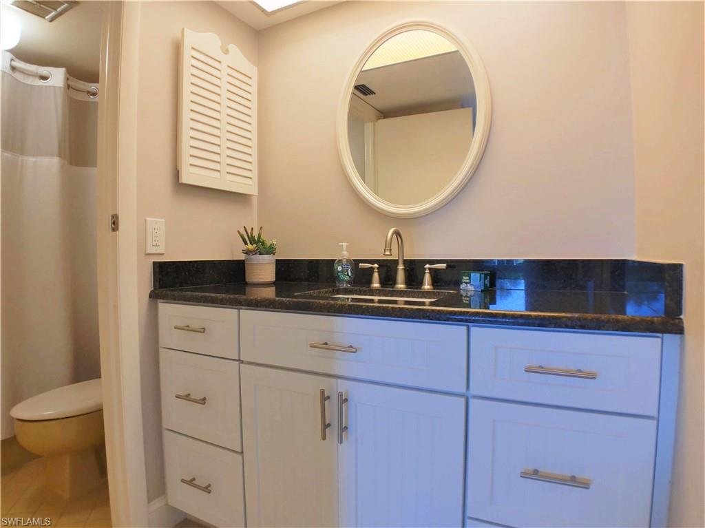 108 Penny Lane, Unit 4 Naples, FL 34112 - Photo 31 of 33 a bathroom with a sink and a mirror