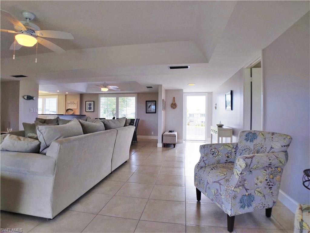 108 Penny Lane, Unit 4 Naples, FL 34112 - Photo 7 of 33 a living room with furniture and a chandelier
